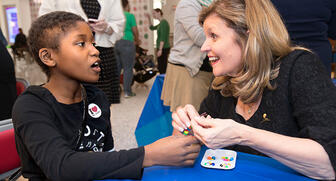 J.C. Penney jewelry executive Pam Mortensen was one of 14 people who took the trip to St. Jude Children’s Research Hospital in Memphis with Jewelers for Children last month. Here, Mortensen, who’s also the current JFC board chair, helps a young patient finish up her bracelet. 20171110_JFC-header.jpg