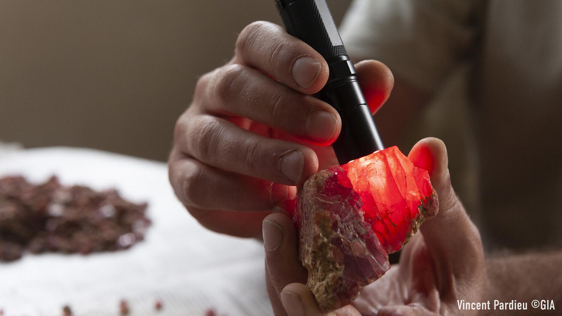 A red gemstone is examined during a 2012 GIA Laboratory Bangkok Field Expedition in Morogoro and Mahenge, Tanzania for ruby and spinel.